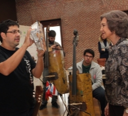 Fabio Chávez, director de la Orquesta, explica a Su Majestad la Reina como se construyen instrumentos músicales a partir materiales reciclados